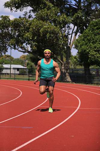 new zealand man in green tank top running on track field during daytime person